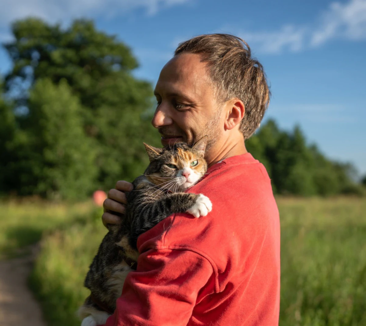 Person outdoors holding their cat